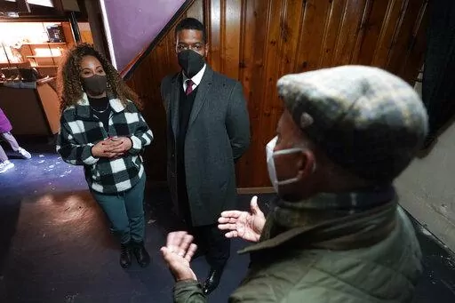 Tilicia Owens and Environmental Protection Agency Administrator Michael Regan, center, listen to Detroit Water and Sewerage Department director Gary Brown in her basement Friday, Feb. 18, 2022, in Detroit. They discussed the city’s $15 million effort to provide flood prevention pumps and other equipment in 11 neighborhoods. Part of the money will come from the $350 billion Coronavirus State and Local Fiscal Recovery Funds which can be used by states, counties and cities to recover from the pan