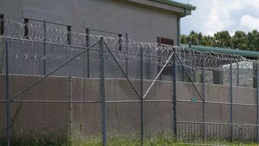 Rolls of razor wire line the top of the security fencing at the Raymond Detention Center in Raymond, Miss., on Aug. 1, 2022. Four prisoners are on the loose after escaping over the weekend from the Mississippi jail already under federal scrutiny for alleged mismanagement. In an escape that began around 8 p.m. Saturday, the four detainees broke free from the Raymond Detention Center, a facility near the state capital of Jackson, through breaches in a cell and in the roof, Hinds County Sheriff Tyr
