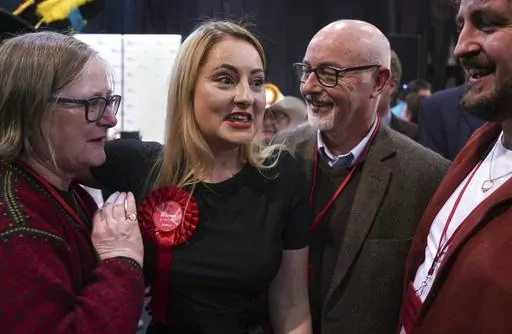 Labour Party candidate Gen Kitchen celebrates with her family after being declared winner in the Wellingborough by-election at the Kettering Leisure Village, Northamptonshire, Friday Feb. 16, 2024. (Joe Giddens/PA via AP)