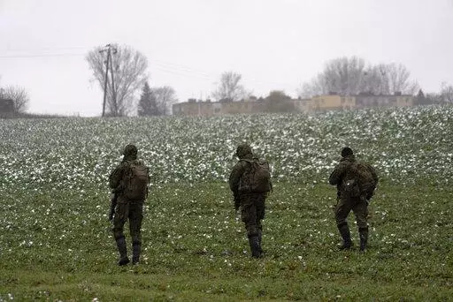 Polish soldiers search for missile wreckage in the field, near the place where a missile struck, in a farmland at the Polish village of Przewodow, near the border with Ukraine, Thursday, Nov. 17, 2022. (AP Photo/Vasilisa Stepanenko)