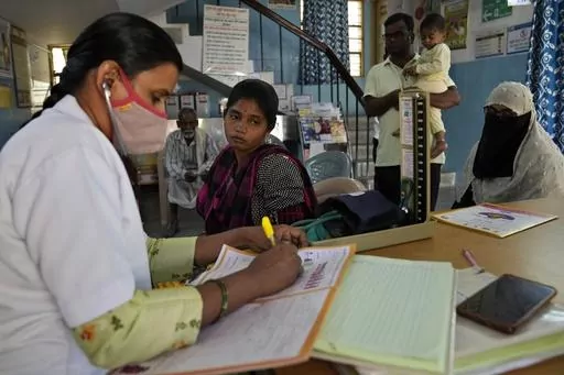 A nurse notes the measurements after checking vital signs of a pregnant woman during her routine check up at Zaheerabad health care center which runs on rooftop solar power, in Raichur, India, Wednesday, April 19, 2023. In semi-urban and rural regions of India and other developing countries with unreliable power grids, decentralized renewable energy — especially solar — is making all the difference in delivering modern health care. (AP Photo/Aijaz Rahi)