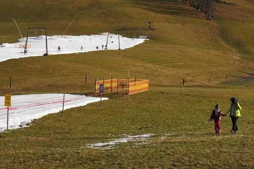 People walk across a slope in Filzmoos, Austria, on Jan. 6, 2023. Europe has dodged an energy apocalypse this winter, economists and officials say, thanks to unusually warm weather and efforts to find other sources of natural gas after Russia cut off most of its supply to the continent. (AP Photo/Matthias Schrader, File)