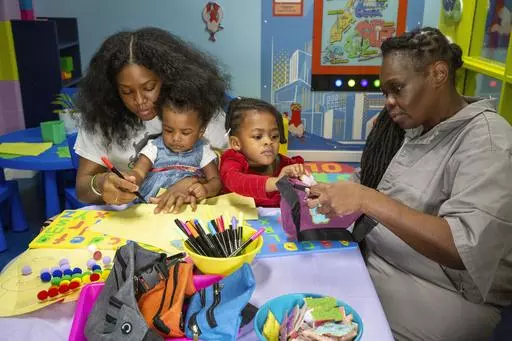 Inmate Nadine Leach, 43, right, visits with her grandchildren and daughter Lashawna Jones, 27, in the newly opened preschool play and learn visitation hub in the Rose M. Singer Center at the Rikers Island jail complex in the Bronx borough of New York, on Tuesday, May 7, 2024. (AP Photo/Ted Shaffrey)