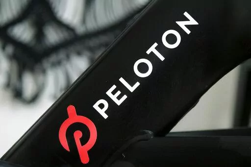 This Nov. 19, 2019 photo shows a Peloton logo on the company's stationary bicycle in San Francisco, Calif.  Peloton told employees Thursday, Oct. 6, 2022,  that it will cut approximately 500 jobs, or about 12% of its workforce, as post- pandemic sales of its indoor exercise equipment continues to tail off.  (AP Photo/Jeff Chiu, File)