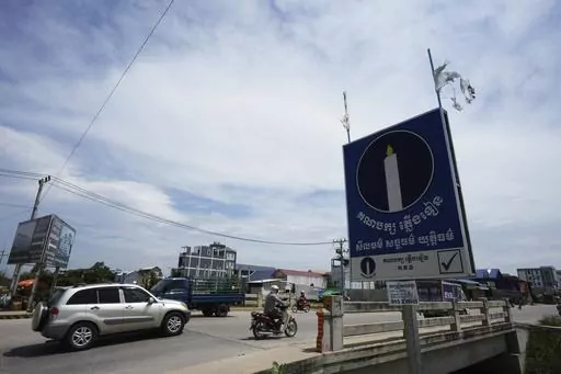 Political party Candlelight Party's poster, right, is displayed near a bridge outside Phnom Penh, Cambodia, Thursday, May 25, 2023. Cambodia’s top opposition party was barred Thursday, May 25, 2023, from participating in elections set for July after the Constitutional Council refused to overturn a decision not to register the party over a paperwork issue. (AP Photo/Heng Sinith)