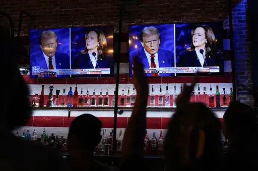 Viewers cheer as they watch a debate between Democratic presidential nominee Vice President Kamala Harris and Republican presidential nominee former President Donald Trump at the Angry Elephant Bar and Grill, Sept. 10, 2024, in San Antonio. (AP Photo/Eric Gay, File)