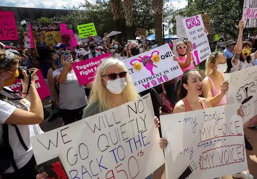 Participants wave signs as they walk back to Orlando City Hall during the March for Abortion Access, Oct. 2, 2021, in Orlando, Fla. The Florida Supreme Court on Monday, April 1, 2024, upheld the state's ban on most abortions after 15 weeks of pregnancy, which means a subsequently passed six-week ban can soon take effect. (Chasity Maynard/Orlando Sentinel via AP, File)