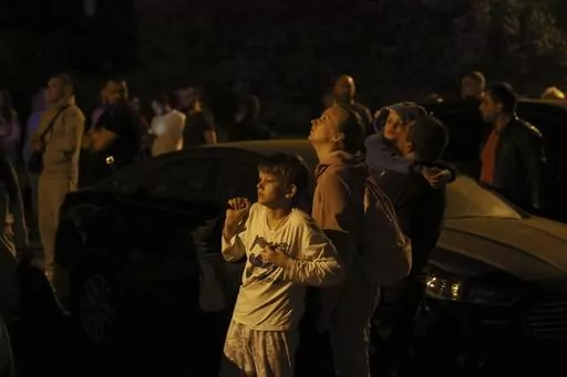 People look at a fire on the top of residential building following a drone attack, in Kyiv, Ukraine, Saturday, May 20, 2023. Russian air attacks have escalated to near-nightly raids over the last month. The attacks come at night, when most in Kyiv are sound asleep. The sirens wail across the Ukrainian capital, rousing bleary-eyed residents, who, after 15 months of war, have customized individual routines to cope with Russia’s latest air campaign. (AP Photo/Alex Babenko, File)