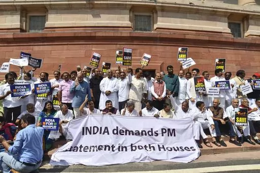 Opposition lawmakers demanding a statement from Prime Minister Narendra Modi on the violence in Manipur state carry placards and a banner with name of "INDIA" outside the Parliament building in New Delhi, India, Monday, July 24, 2023. India’s fractured opposition parties have joined forces in a rare show of unity and formed an alliance called 'INDIA' to unseat the popular but polarizing prime minister Narendra Modi and his Hindu nationalist Bharatiya Janata Party. Last week, more than two doze