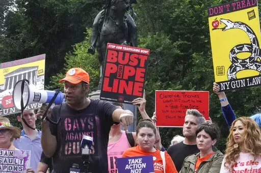 Jay Walker, third from left, co-founder of Gays Against Guns, speaks into a megaphone during a rally against the Supreme Court decision striking down New York's gun law, Thursday, June 23, 2022, in New York.  When the U.S. Supreme Court struck down New York’s tight restrictions on who can carry a handgun, condemnation erupted from liberal leaders and activists. (AP Photo/Bebeto Matthews)