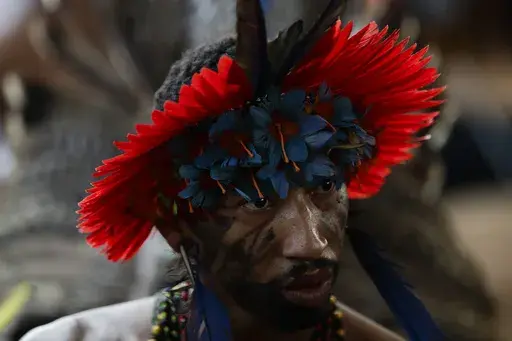 An Indigenous person attends a ceremony celebrating the return of the Tupinamba Indigenous people's sacred cloak to Brazil, in Rio de Janeiro, Thursday, Sept. 12, 2024. The garment, made from bird feathers and plant fibers, was repatriated to Brazil after having spent more than 300 years in the National Museum of Denmark. (AP Photo/Bruna Prado)