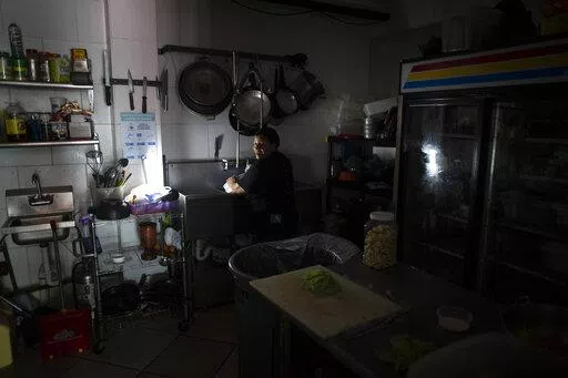 Workers at Las Palmas Cafe work with the power of an electricity generator during an island-wide blackout, in San Juan, Puerto Rico, Thursday, April 7, 2022. More than a million customers in Puerto Rico remained without electricity on Thursday after a fire at a main power plant caused the biggest blackout so far this year across the U.S. territory, forcing it to cancel classes and shutter government offices. (AP Photo/Carlos Giusti)