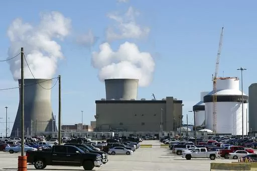 Reactors for Unit 3 and 4 sit at Georgia Power's Plant Vogtle nuclear power plant on Jan. 20, 2023, in Waynesboro, Ga., with the cooling towers of older Units 1 and 2 billowing steam in the background. Company officials announced Wednesday, May 24, 2023, that Unit 3 would reach full power in coming days, after years of delays and billions in cost overruns. (AP Photo/John Bazemore)
