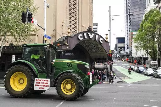 A tractor drives down Queen street in central Auckland during a protest on climate change proposals to make New Zealand farmers pay for greenhouse gas emissions, Thursday, Oct. 20, 2022. New Zealand farmers drove their tractors to towns around New Zealand on Thursday in protest at a proposed new tax on cow burps and other farm greenhouse gas emissions. (Dean Purcell/New Zealand Herald via AP)