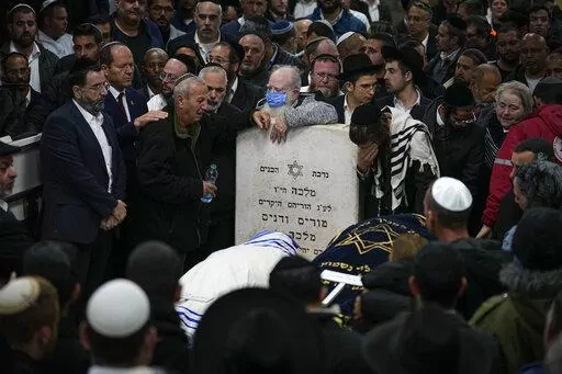 Mourners attend the funeral of Israeli couple Eli Mizrahi and his wife, Natalie, victims of a shooting attack Friday in east Jerusalem, at the cemetery in Beit Shemesh, Israel, early Sunday, Jan. 29, 2023. On Friday a Palestinian gunman opened fire outside an east Jerusalem synagogue, killing the couple and another five people, including a 70-year-old woman, and wounding three others before he was shot and killed by police, officials say. It was the deadliest attack on Israelis since 2008 and ra