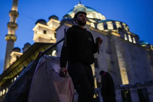 Ergin Dogan, 29, pulls his cart as he harvests for discarded cartons next to Yeni mosque in Istanbul, Turkey, Tuesday, Feb. 26, 2025. (AP Photo/Francisco Seco)
