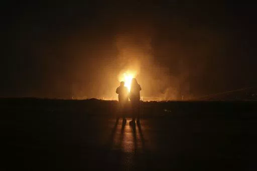 Two men look at flames after a natural gas pipeline explodes outside the city of Boroujen in the western Chaharmahal and Bakhtiari province, Iran, in early Wednesday, Feb. 14, 2024. Explosions struck a natural gas pipeline in Iran early Wednesday, with an official blaming the blasts on a "sabotage and terrorist action" in the country as tensions remain high in the Middle East amid Israel's war on Hamas in the Gaza Strip. (Reza Kamali Dehkordi/Fars News Agency via AP)