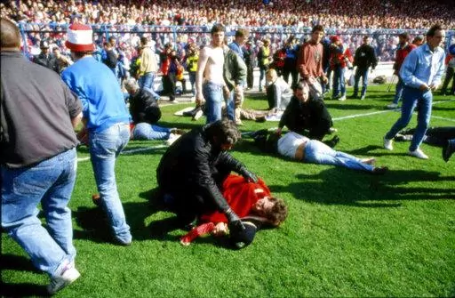 Stewards and supporters tend and care for wounded supporters on the field at Hillsborough Stadium, in Sheffield, England, April 15, 1989. The crowd deaths from a Halloween festival in Seoul, South Korea, on Saturday, Oct. 29, 2022 have added to the long list of people who have been crushed at a major event. Such tragedies have been occurring around the world for a long time at concerts, sports events and religious gatherings.  (AP Photo, File)