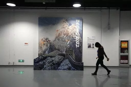 A person walks past a display of the Great Wall of China in a lower level of the Main Media Center ahead of the 2022 Winter Olympics, Jan. 30, 2022, in Beijing. (AP Photo/Jeff Roberson, File)