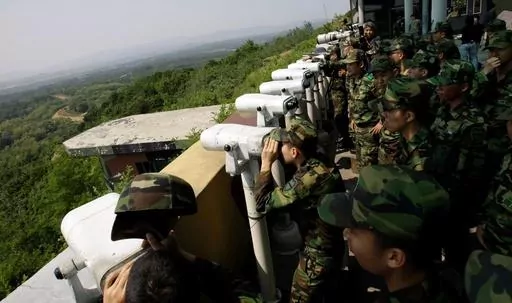 South Korean soldiers look at the North Korean side through binoculars at Dora Observation Post in the demilitarized zone, DMZ, near the border village of Panmunjom that separates the two Koreas since the Korean War, in Paju, north of Seoul, South Korea, Wednesday, May 27, 2009. A series of low-slung buildings and somber soldiers dot the landscape of the DMZ, the swath of land between North and South Korea where a soldier on a tour crossed into North Korea on Tuesday, July 18, 2023, under circum