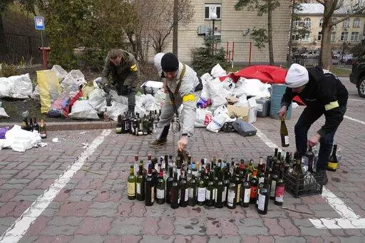 Members of civil defense prepare Molotov cocktails in a yard in Kyiv, Ukraine, Sunday, Feb. 27, 2022. A Ukrainian official says street fighting has broken out in Ukraine's second-largest city of Kharkiv. Russian troops also put increasing pressure on strategic ports in the country's south following a wave of attacks on airfields and fuel facilities elsewhere that appeared to mark a new phase of Russia's invasion. (AP Photo/Efrem Lukatsky)