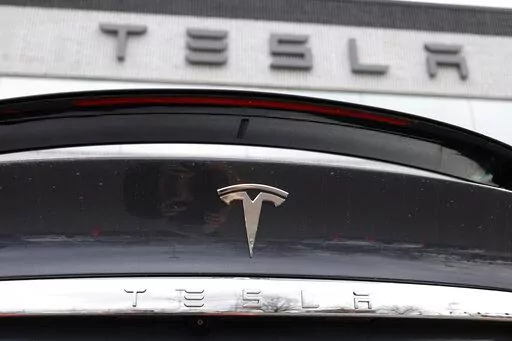 In this April 26, 2020 photo, the company logo shines off the rear deck of an unsold 2020 Model X at a Tesla dealership in Littleton, Colo. Tesla’s sales from April through June 2022 fell to their lowest quarterly level since last fall as supply chain issues and pandemic restrictions in China hobbled production of its electric vehicles. (AP Photo/David Zalubowski, File)