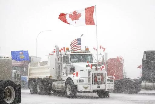 Anti-COVID-19 vaccine mandate demonstrators gather as a truck convoy blocks the highway at the busy U.S. border crossing in Coutts, Alberta, Canada, Monday, Jan. 31, 2022.  Thousands of antivaccine protesters descended on Canada’s capital of Ottawa in frigid temperatures to protest vaccine mandates, masks and restrictions over the weekend and some remain, blocking traffic around Parliament Hill in what has been the biggest pandemic protest in the country to date.(Jeff McIntosh/The Canadian Pre