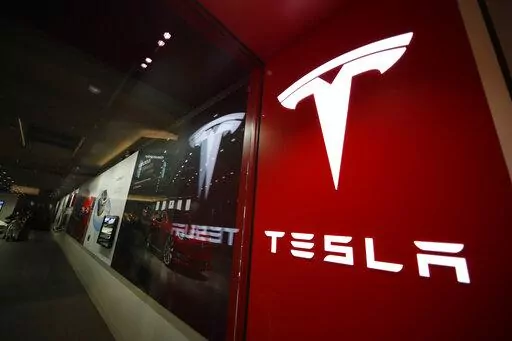 A sign bearing the company logo outside a Tesla store in Cherry Creek Mall in Denver is seen here on Feb. 9, 2019. Tesla is recalling nearly 363,000 vehicles with its “Full Self-Driving” system to fix problems with the way it behaves around intersections and following posted speed limits, the National Highway Traffic Safety Administration announced Thursday, Feb. 16, 2023. (AP Photo/David Zalubowski, File)