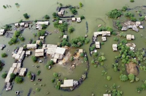 Homes are surrounded by floodwaters in Sohbat Pur city, a district of Pakistan's southwestern Baluchistan province, Aug. 30, 2022. This past year has seen a horrific flood that submerged one-third of Pakistan, one of the three costliest U.S. hurricanes on record, devastating droughts in Europe and China, a drought-triggered famine in Africa and deadly heat waves all over. (AP Photo/Zahid Hussain, File)