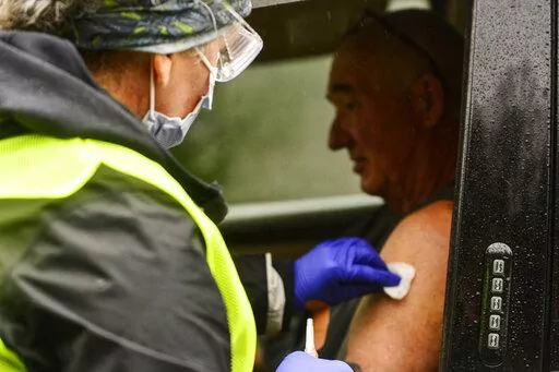 FILE - Registered nurse Megan Chamberlain gives a flu shot to Anthony Devitt, of Marlboro, Vt., during a flu vaccine clinic on Route 9, in Brattleboro, Vt., that was hosted by Visiting Nurse and Hospice for Vermont and New Hampshire on Tuesday, Oct. 26, 2021. (Kristopher Radder/The Brattleboro Reformer via AP, File)