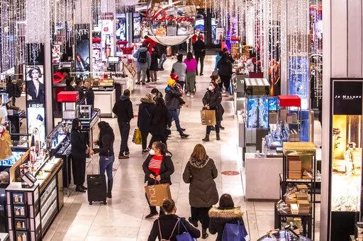 Shoppers walk through Macy's  on Nov. 26, 2021, in New York.  Americans slowed their spending from November to December as a trifecta of product shortages, surging prices and a surge of the highly contagious omicron curtailed spending. Retail sales fell 1.9% in December compared with the previous month when sales increased 0.3%, the U.S. Commerce Department said Friday, Jan. 14, 2022. (AP Photo/Brittainy Newman, File)