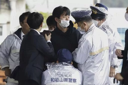 A man who was later identified as Ryuji Kimura is arrested after what appeared to be a pipe bomb was thrown at Japanese Prime Minister Fumio Kishida during his visit at a port in Wakayama, western Japan, on April 15, 2023. Prosecutors in Japan indicted the 24-year-old man Wednesday, Sept. 6, 2023 on attempted murder and other charges in the explosive attack on Prime Minister Fumio Kishida in April, Japanese media reported. (Kyodo News via AP, File)