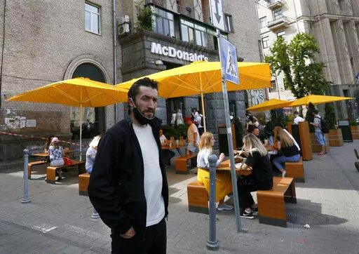 People, some of them still in masks to protect against coronavirus, enjoy outdoor McDonald's meal in downtown Kyiv, Ukraine, on June 9, 2020. McDonald's announced Thursday, Aug. 10, 2022, that the company will start reopening restaurants in Ukraine in the coming months, a symbol of the war-torn country's return to some sense of normalcy and a show of support after the American fast-food chain pulled out of Russia. (AP Photo/Efrem Lukatsky, File)