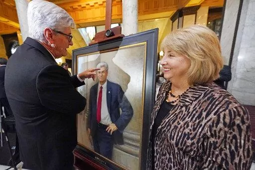 Former Gov. Phil Bryant, left, studies his official portrait with his wife Deborah Bryant, following its unveiling at the Mississippi Capitol in Jackson, Miss., Tuesday, March 22, 2022. His portrait will join those of previous governors hanging in the Capitol while his wife's portrait will hang with other first ladies at the Old Capitol Museum. (AP Photo/Rogelio V. Solis)