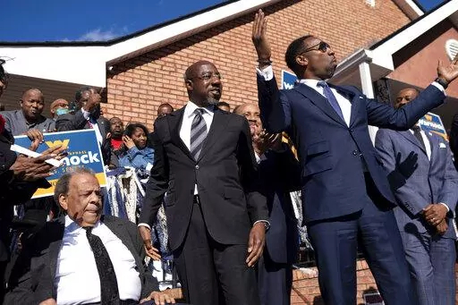 Sen. Raphael Warnock, D-Ga., center, prepares to speak at a rally after being introduced by Civil Rights icon Andrew Young, left, and Atlanta Mayor Andre Dickens on Sunday, Nov. 27, 2022, in Atlanta. (AP Photo/Ben Gray)