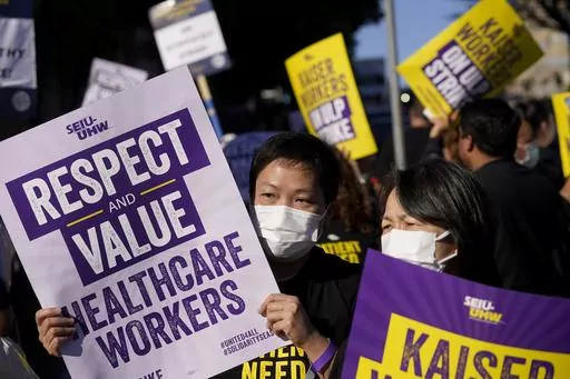 Medical workers and supporters carry signs and march as they protest outside of a Kaiser Permanente facility in San Francisco, Wednesday, Oct. 4, 2023. Thousands of workers who were asked to make sacrifices during the pandemic even as corporate profits soared are now asking for better pay and protections(AP Photo/Jeff Chiu, File)