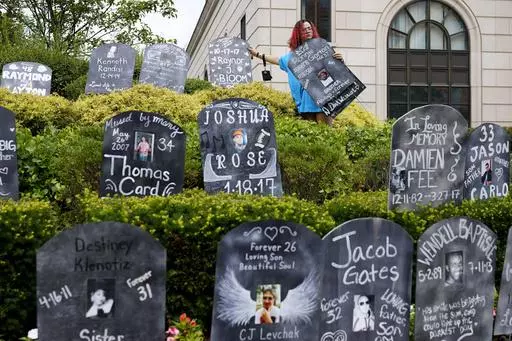 Jayde Newton helps to set up cardboard gravestones with the names of victims of opioid abuse outside the courthouse where the Purdue Pharma bankruptcy is taking place in White Plains, N.Y., on Aug. 9, 2021. A three-judge panel of the 2nd U.S. Circuit Court of Appeals in New York on Tuesday, May 30 overturned a lower court’s 2021 ruling that found bankruptcy courts did not have the authority to protect members of the Sackler family who own the company and who have not filed for bankruptcy prote
