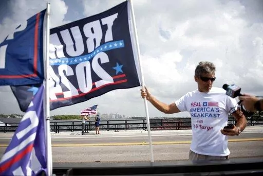 Supporters of Donald Trump, members of the media and law enforcement gather near Mar-a-Lago  in Palm Beach, Fla., on Tuesday, August 9, 2022. (Meghan McCarthy/The Palm Beach Post via AP)