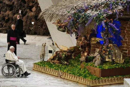 Pope Francis looks at a nativity scene as he leaves after his weekly general audience in the Paul VI Hall, at the Vatican, Wednesday, Dec. 21, 2022. (AP Photo/Andrew Medichini)