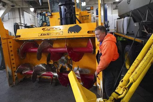 Heavy equipment operator Don Beitz walks around a giant snow thrower while preparing for the impending snowstorm that is expected to dump several feet of snow on the area from 7 p.m. tonight until 7 p.m. Friday at the New York State Thruway's Walden Garage in Cheektowaga, N.Y. on Thursday, Nov. 17, 2022. (Derek Gee/The Buffalo News via AP)