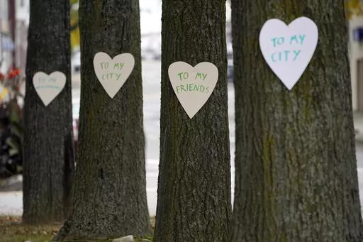 Heart-shaped cut-outs with messages of positivity adorns trees in downtown Lewiston, Maine, Thursday, Oct. 26, 2023. The signs are some of the 100 hearts put up by Miaa Zellner of Turner, Maine, to show her love and support for the community in the wake of Wednesday's mass shootings. (AP Photo/Robert F. Bukaty)