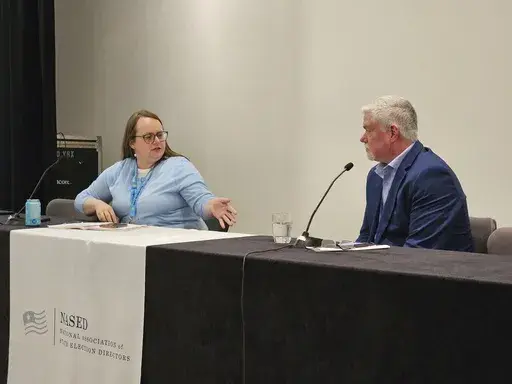 Molly Woon, left, elections director with the Oregon Secretary of State's Office, leads a panel discussion on mail voting on Tuesday, July 23, 2024, in Minneapolis, at the summer conference of the National Association of State Election Directors. She's speaking with Steven Carter, manager of election and government programs for the U.S. Postal Service. State election directors from across the country expressed serious concerns to him that mail system won't be able to handle an expected crush of 