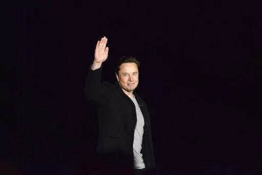 Elon Musk waves while providing an update on SpaceX's Starship, Thursday, Feb. 10, 2022, near Brownsville, Texas. In April 2022, a group of Tesla shareholders suing Musk over some 2018 tweets about taking the company private is asking a federal judge to order him to stop commenting on the case. (Miguel Roberts/The Brownsville Herald via AP, File)