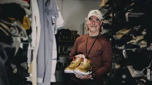 This photo provided by the Portland Rescue Mission shows James Free posing for a photo with a pair of of gold Nike Air Jordan 3 sneakers at the Portland Rescue Mission on Sunday, Oct. 30, 2023, in Portland, Ore. The sneakers, designed in 2019 for filmmaker Spike Lee, that were donated to the homeless shelter, sold for nearly $51,000 at auction on Monday, Dec. 18. (Aaron Ankrom/Portland Rescue Mission via AP)