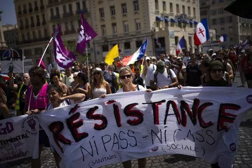 Protesters march during a demonstration to denounce a COVID-19 health pass needed to access restaurant, long-distance trains and other venues. in Marseille, southern France, Saturday, Aug. 14, 2021. The run-up to the April election comes in a context of mounting violence targeting elected officials in France, with holders of public officers targeted for their politics and by opponents of COVID-19 vaccinations restrictions. (AP Photo/Daniel Cole, File)