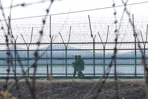 South Korean army soldiers patrol along the barbed-wire fence in Paju, South Korea, near the border with North Korea, Thursday, Feb. 16, 2023. South Korea called North Korea "our enemy" in its biennial defense document published Thursday, reviving the label for its rival for the first time in six years, as tensions worsen between the two. (AP Photo/Ahn Young-joon)