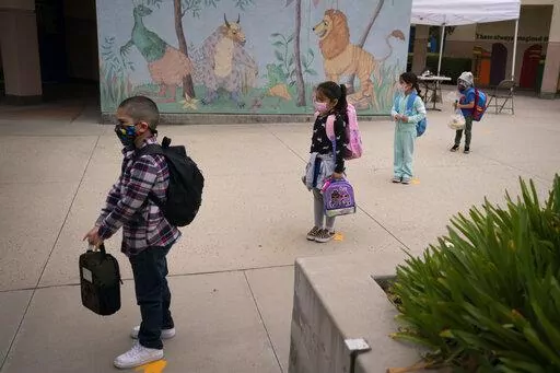 Socially distanced kindergarten students wait for their parents to pick them up on the first day of in-person learning at Maurice Sendak Elementary School on April 13, 2021, in Los Angeles. Vaccination rates for U.S. kindergarteners in 2022 saw a significant drop for the second year in a row, according to new data released Thursday, Jan. 12, 2023, and worried federal officials are launching a new campaign to try to help bring them back up. (AP Photo/Jae C. Hong, File)