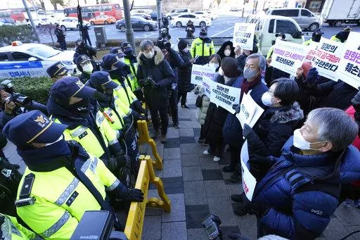 Protesters confront police officers during a rally to oppose Japan's adoption of a new national security strategy near the Japanese Embassy in Seoul, South Korea, Tuesday, Dec. 20, 2022. North Korea threatened Tuesday to take "bold and decisive military steps" against Japan as it slammed Tokyo's adoption of a national security strategy as an attempt to turn the country into an aggressive military power. The banners read "Stop military cooperation between South Korea, the U.S. and Japan military 