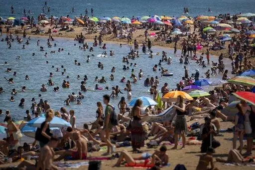 People cool off in the water on a hot and sunny day at the beach in Barcelona, Spain, July 15, 2022. Earth’s fever persisted last year, not quite spiking to a record high but still in the top five or six warmest on record, government agencies reported Thursday, Jan. 12, 2023. (AP Photo/Emilio Morenatti, File)