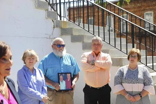 The families of two sisters killed in 2010 in Kingstree, S.C., stand by attorney Lori Murray, far left, who asks prosecutors to release information about why the man charged in the killings has been set free after being found incompetent to stand trial, at a news conference, Monday, May, 9, 2022, in Kingstree. (AP Photo/Jeffrey Collins)